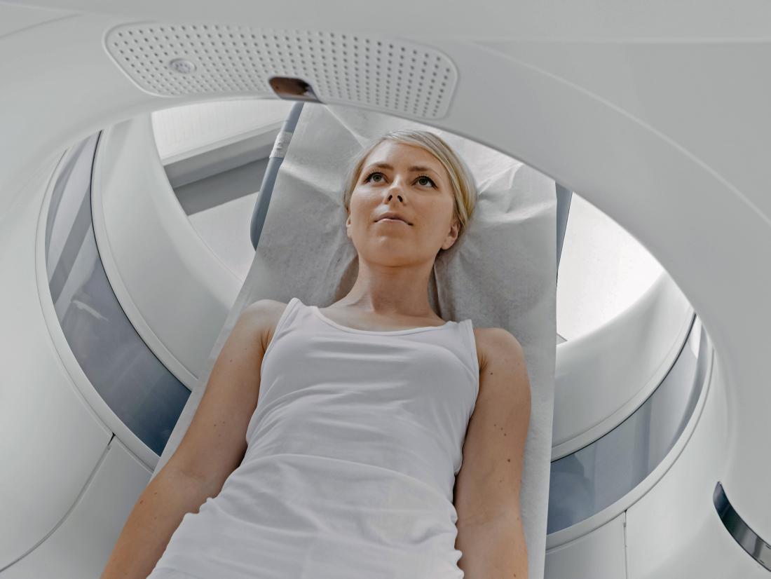 a woman lying down on during a CT scan or MRI
